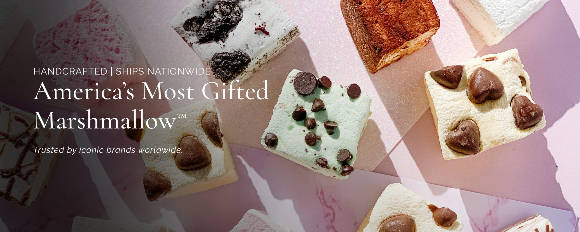A promotional graphic for 'America's Most Gifted Marshmallow' by Ships Nationwide, showcasing an assortment of decorated marshmallows with chocolate chips,  and cookie pieces on a pink background.