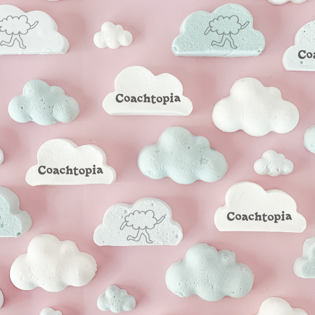 White cloud-shaped stickers with 'Coachtopia' text on a pink background